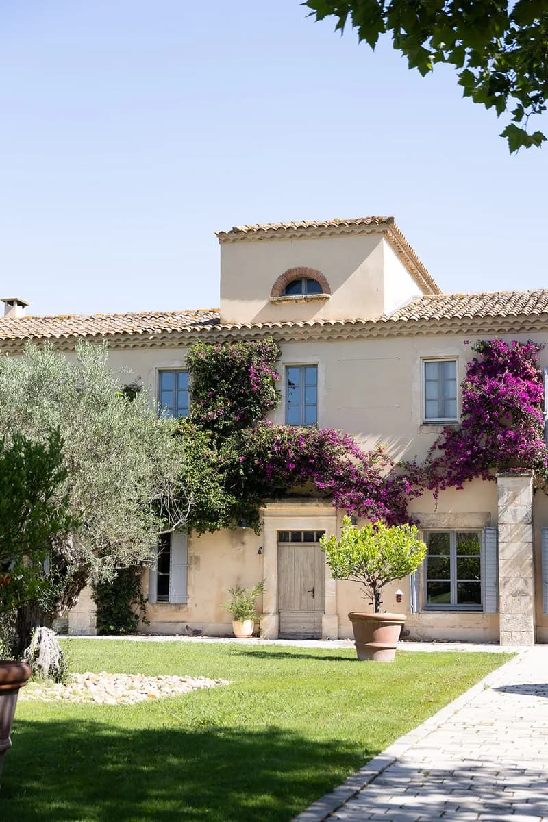 Mas aux volets bleus couvert de bougainvilliers, avec oliviers et allée pavée