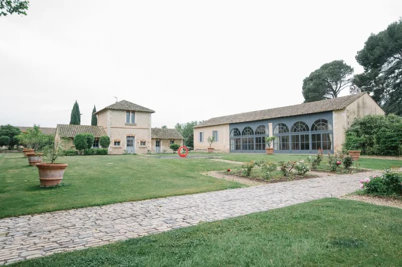Cour du domaine avec allée pavée, jarres en terre cuite et bâtiments en pierre