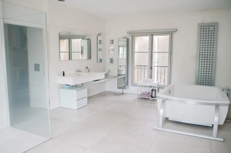 Salle de bains avec double vasque, baignoire îlot et douche vitrée