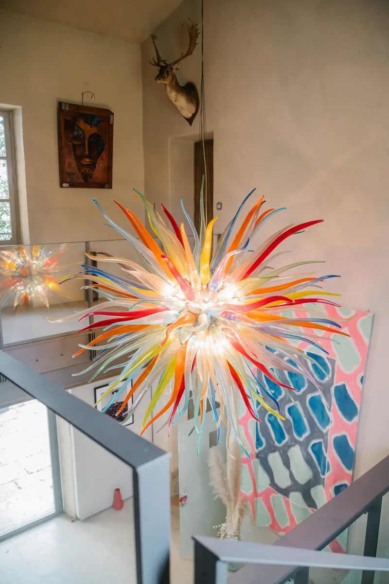 Lustre en verre soufflé multicolore surplombant l'escalier d'une maison