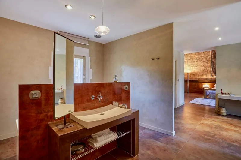 Salle d'eau ouverte sur la chambre, avec vasque et grand miroir